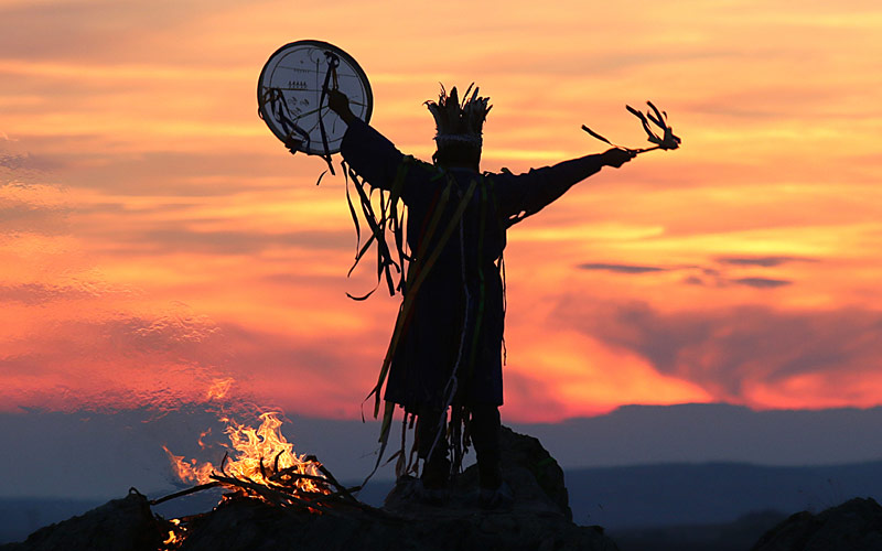 Shaman performing a ritual at sunset